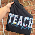 Personalized teacher appliqué shirt featuring TEACH fabric lettering with custom embroidered name underneath and customizable shirt and thread colors.