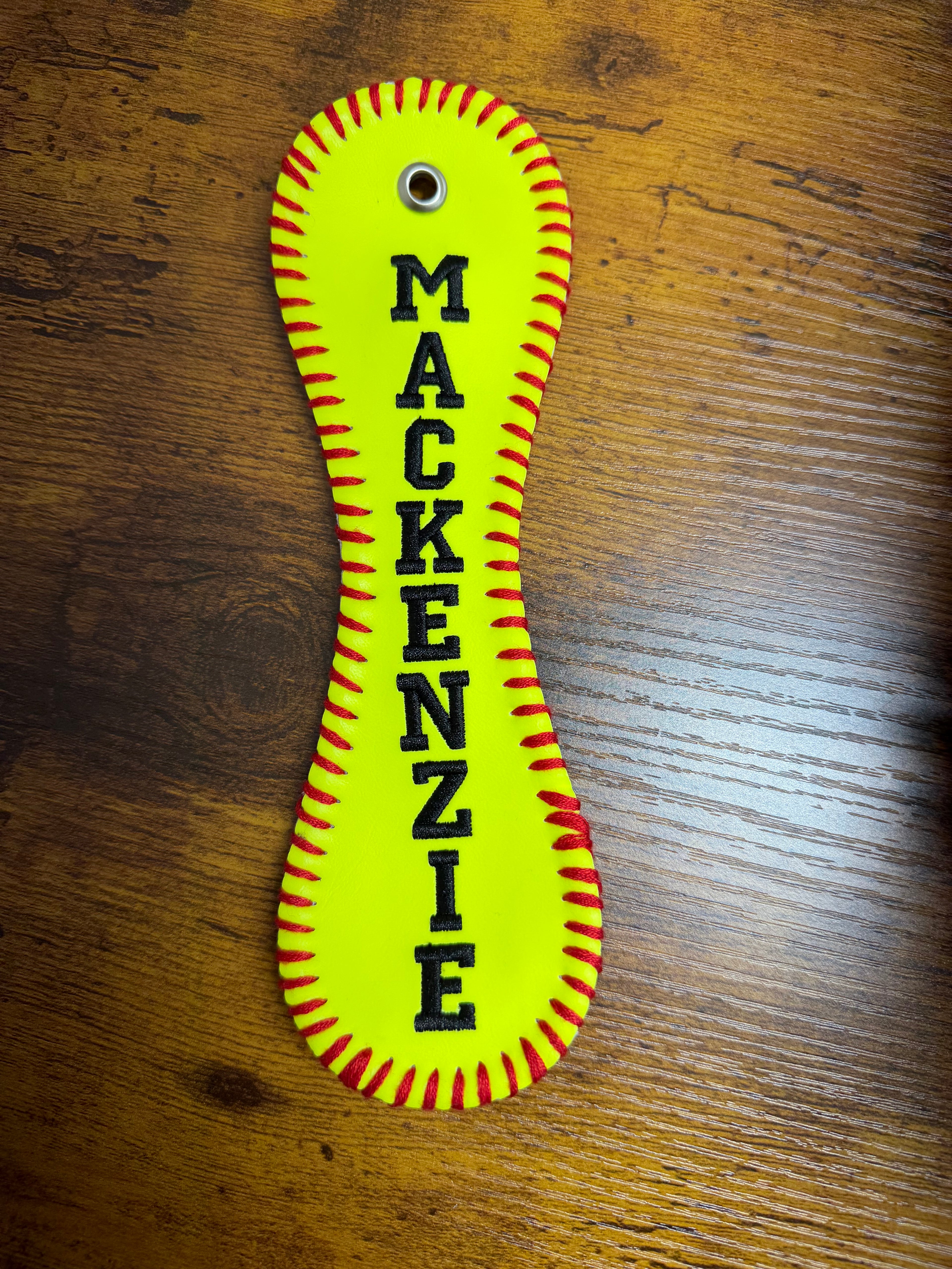 Yellow leather patch with 'MACKENZIE' text on a wooden surface