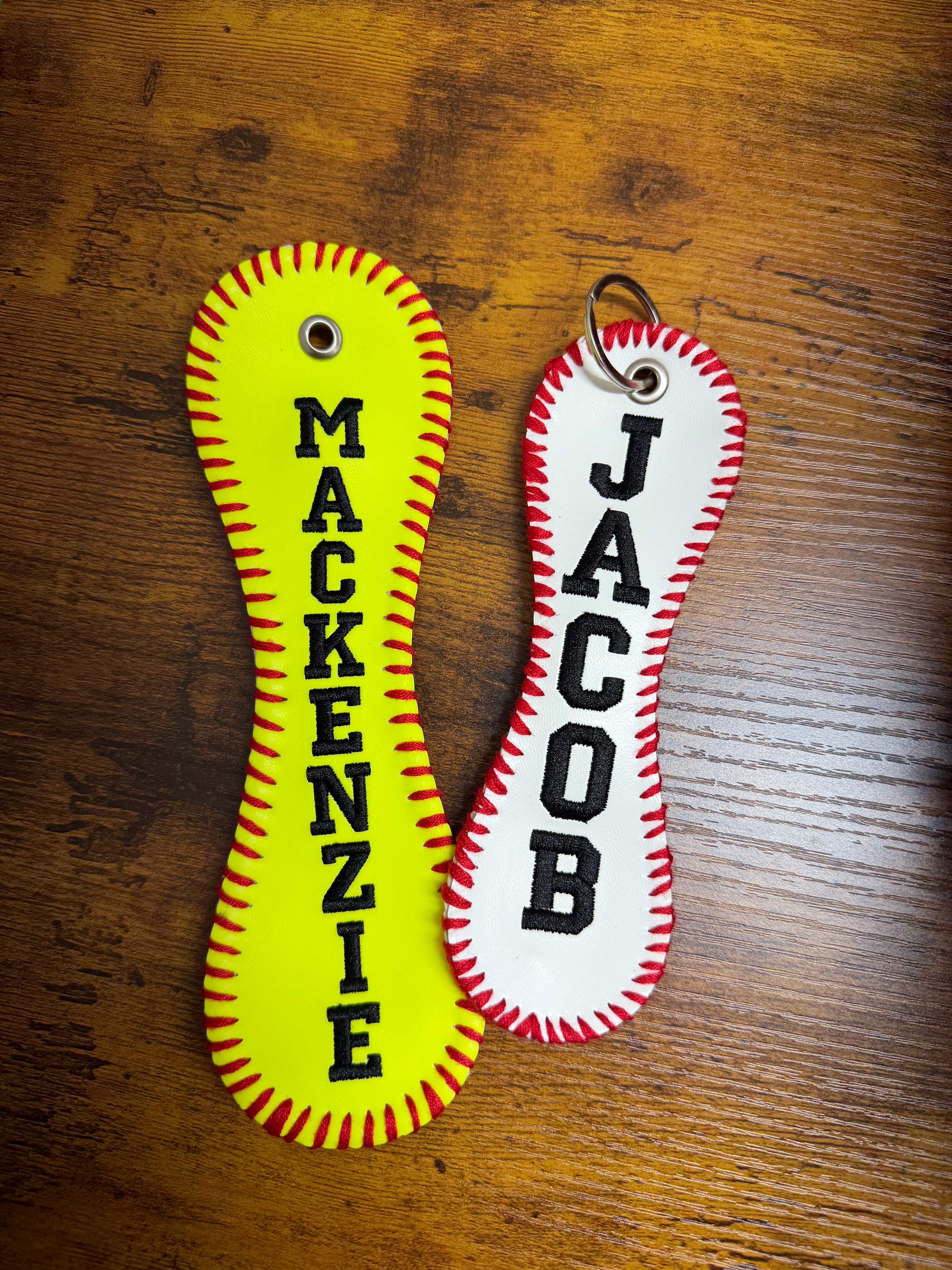 Two keychains with personalized names on a wooden surface