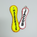Two keychains with personalized names 'Mackenzie' and 'Jacob' on a light gray background.
