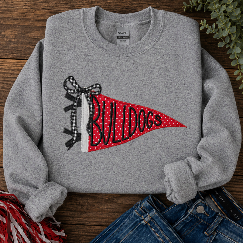 Gray sweatshirt with a red and white bulldog pennant design on a wooden surface.