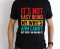 It’s Not Easy Being My Wife’s Arm Candy Graphic Tee - Merch Girls