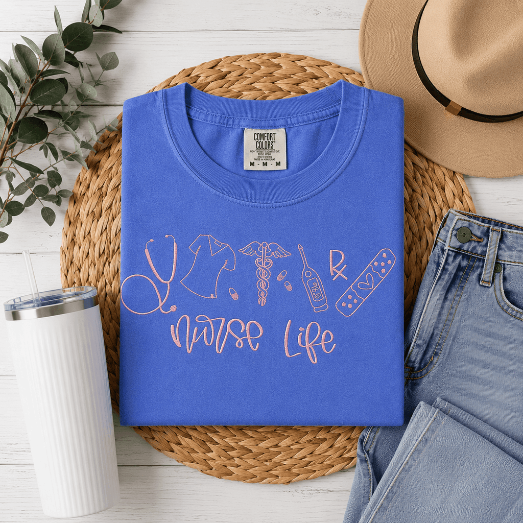 Blue t-shirt with 'Nurse Life' design on a woven mat with accessories.